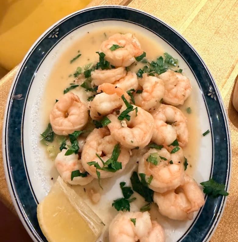 Sinigang na hipon — the prawns on an oval plate with lemon and herbs.